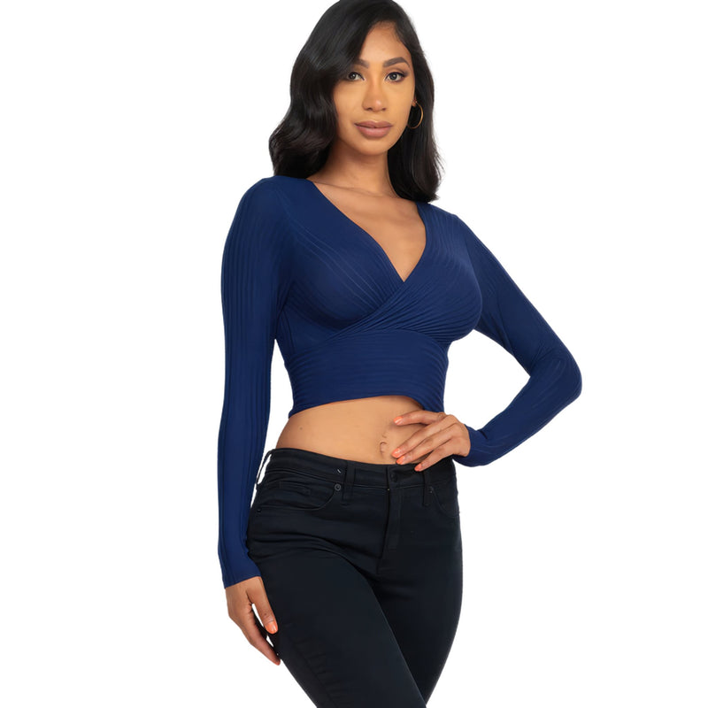 Load image into Gallery viewer, Confident woman modeling a Navy Ribbed Wrap Front Long Sleeve Top with V-neck detailing, paired with dark jeans for a chic look.
