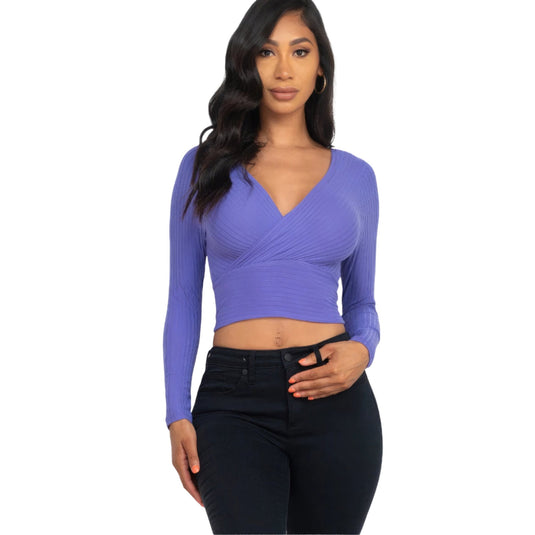 Fashion model in a vibrant Periwinkle Ribbed Wrap Front Long Sleeve Top, adding a pop of color to a modern outfit.