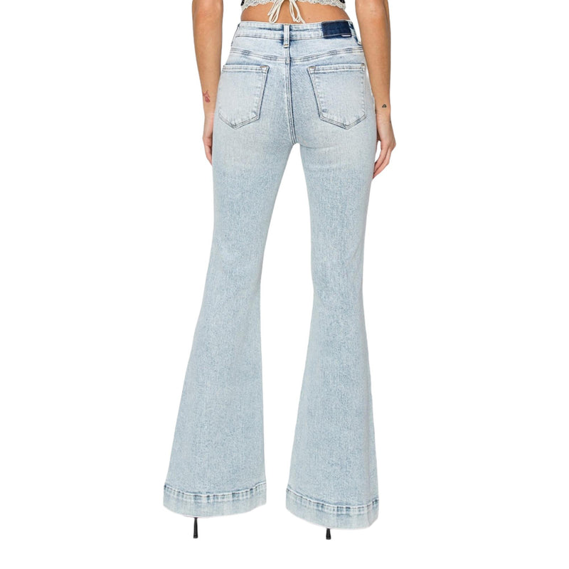 Load image into Gallery viewer,  Model wearing light-washed flare jeans, showcasing the back pockets and wide-leg flare design.
