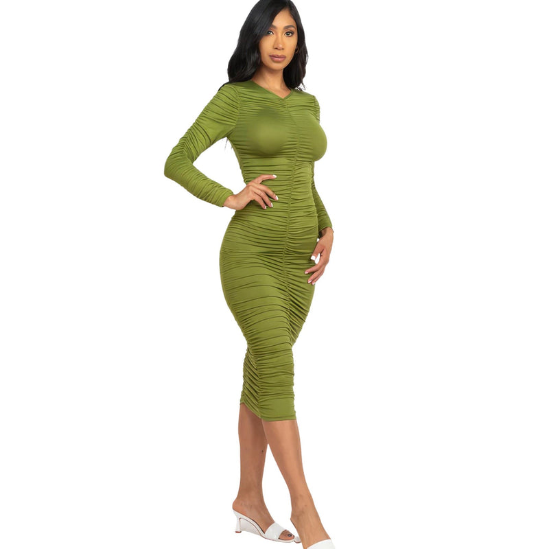 Load image into Gallery viewer, Chic woman models an olive branch green ruched long sleeve midi dress, paired with white open-toe heels for a refined look.
