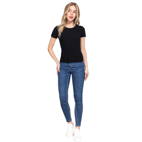 A front view of a woman sporting a classic black rib knit top with short sleeves, complemented by form-fitting blue jeans. The top's stretchable fabric offers a comfortable, figure-flattering fit.