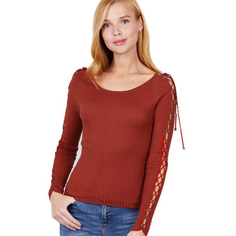 Load image into Gallery viewer, Elegant woman showcasing a rust-colored ribbed sweater with distinctive strappy arm details, posing against a clean, white background.
