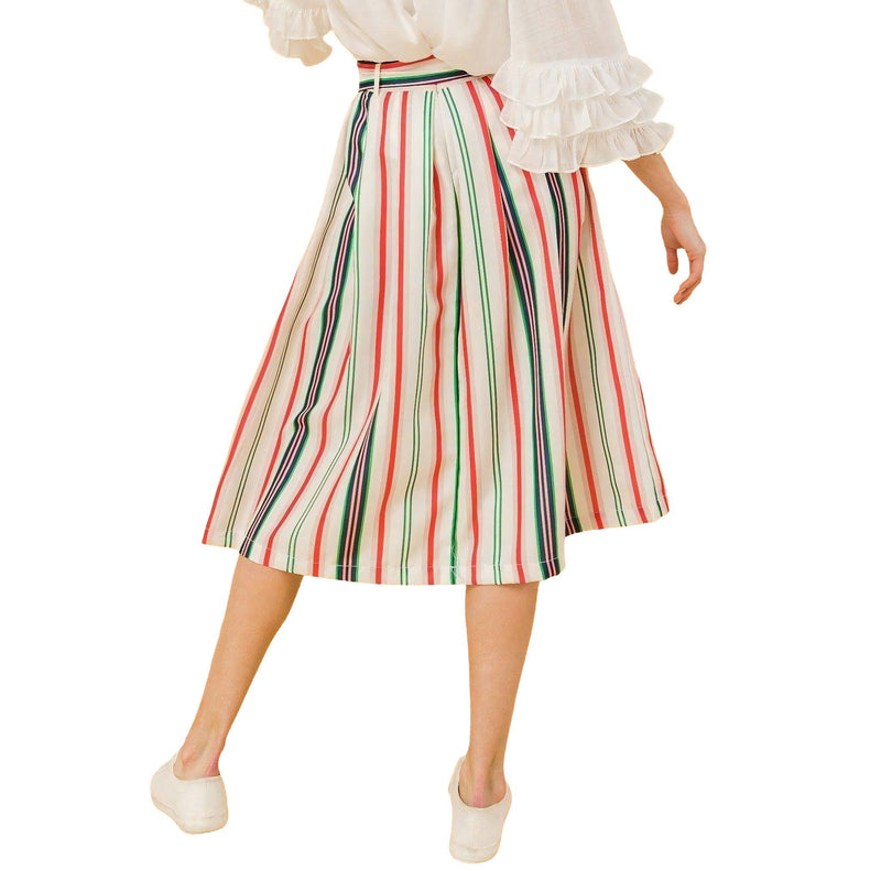 Load image into Gallery viewer, Close-up of the model walking, focusing on the pleated design and bold stripes of the midi skirt, emphasizing the pockets and the fluid movement of the fabric.
