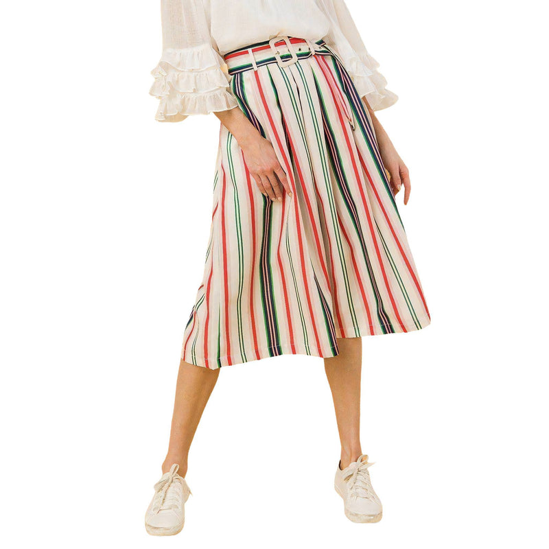 Load image into Gallery viewer, A model in profile view wearing a pleated midi skirt with vertical stripes in shades of red, green, and beige, complemented by a white blouse with ruffle details and casual white sneakers.
