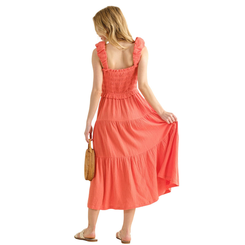 Load image into Gallery viewer, Back view of a woman in a coral Smocked Ruffled Tiered Dress, showing the tiered design and flowy silhouette, perfect for a casual summer look.
