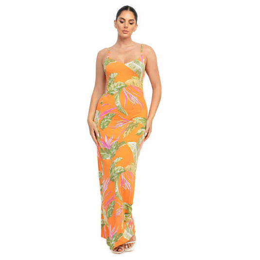 Elegant woman in an orange bodycon maxi dress with tropical leaf prints, showcasing a summer-ready, vibrant look.