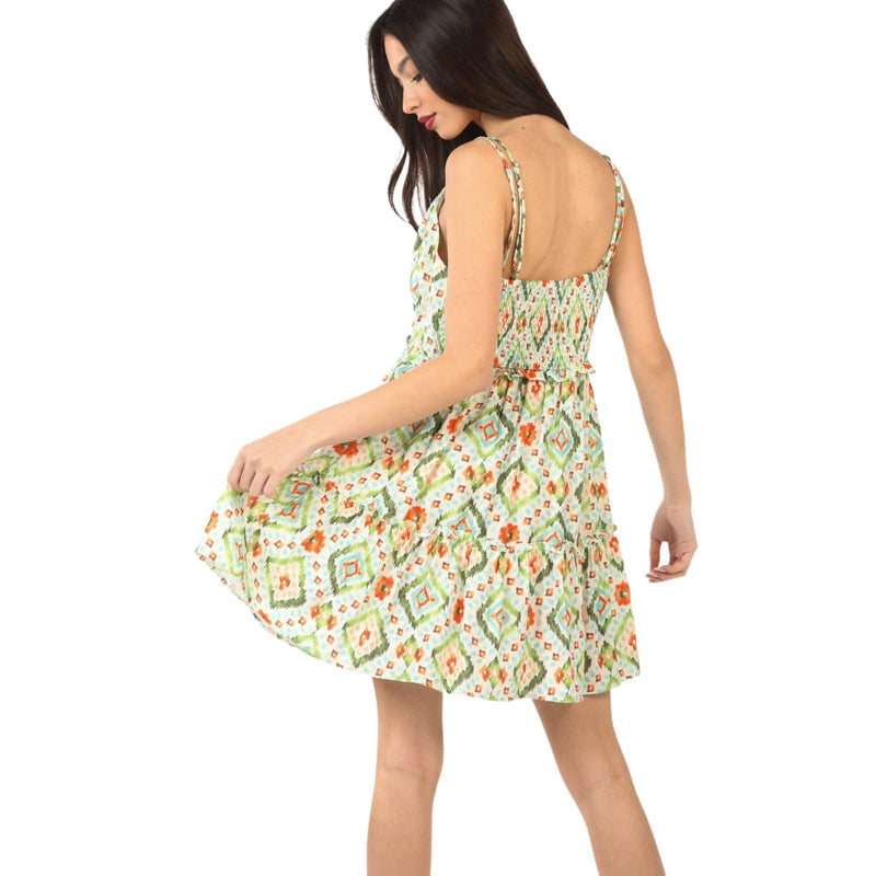 Load image into Gallery viewer, Back view of a woman wearing a Tunnel Detail Multi Color Printed Mini Dress with adjustable spaghetti straps and smocked back. The dress features a vibrant, playful pattern and ruffled design, perfect for sunny days.
