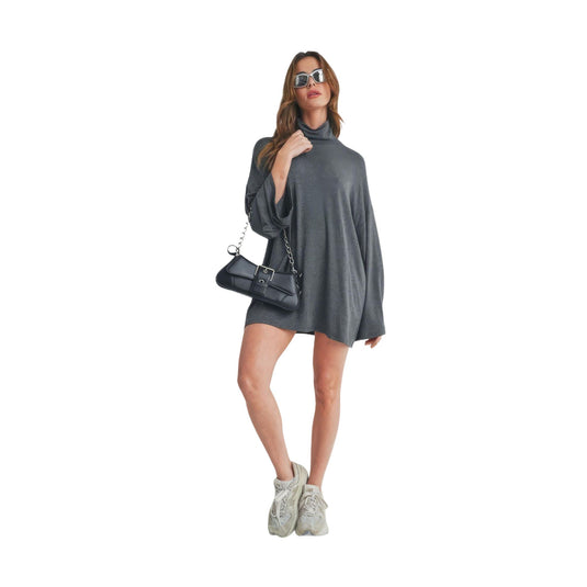 Model showcasing a charcoal gray bell sleeve dress with a high neck, paired with white sneakers and a black chain strap bag.