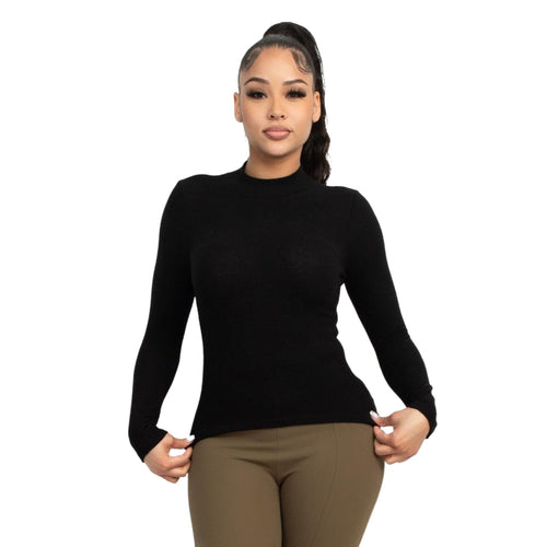 Woman wearing a sleek black mock neck long sleeve top paired with khaki trousers, standing against a white background.