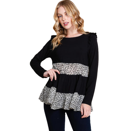A fashionable woman models a black tiered top with velvet animal print mesh contrast, pairing it with dark pants, ideal for a chic ensemble.
