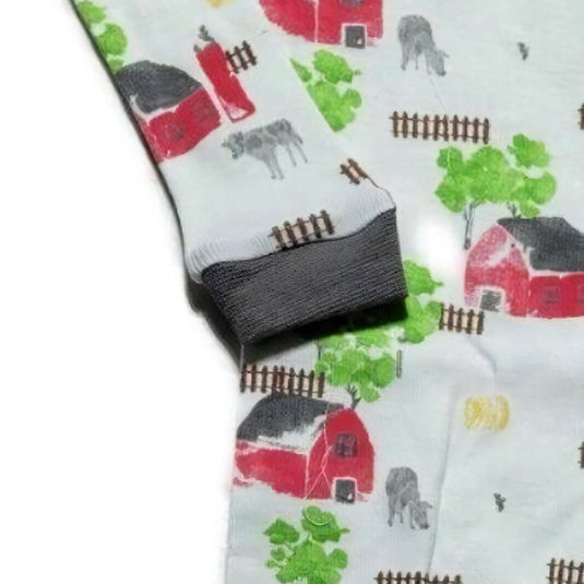 Elastic cuffs of boys' footed pajamas featuring a barnyard design, emphasizing the snug fit around the ankle for cozy sleepwear.