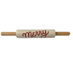 A festive stoneware rolling pin with natural wood handles and 'Merry' scripted in cheerful red lettering on the off-white barrel, ready for holiday baking.